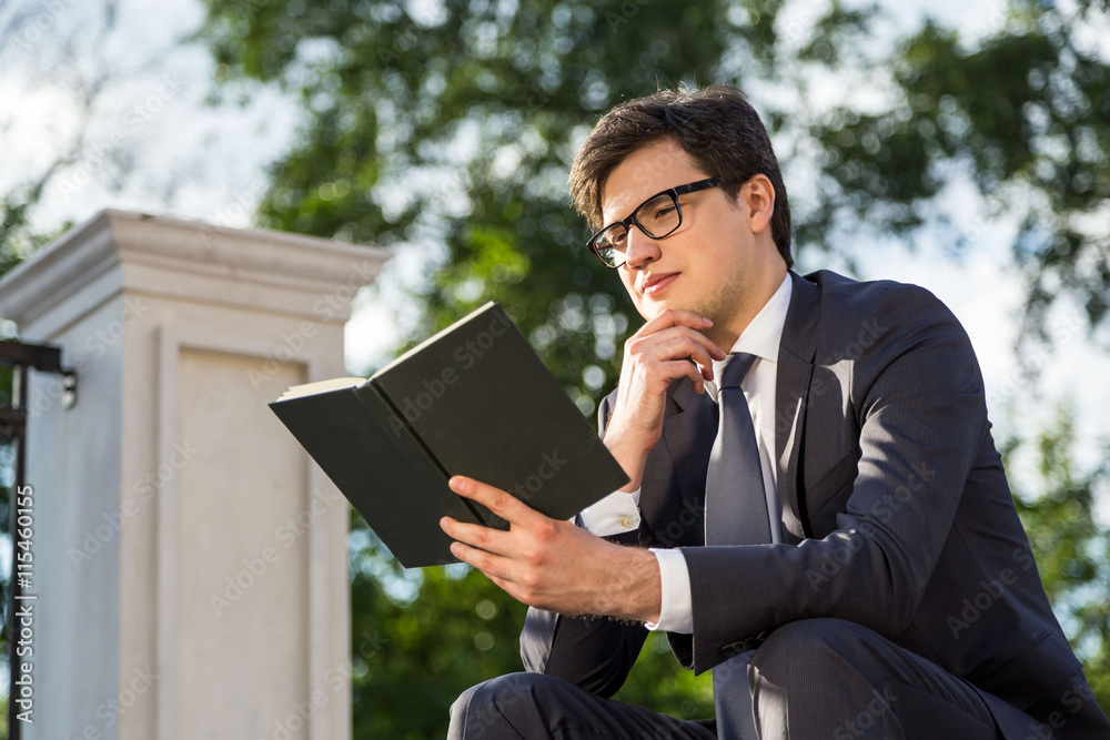 Thoughtful businessman reading book outside Thoughtful businessman reading book outside