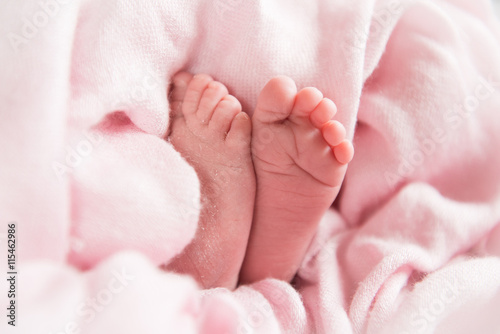 newborn baby feet in pink fabric