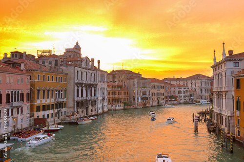 muticolored Venice houses over water of Grand canal at bright orange sunset, Italy