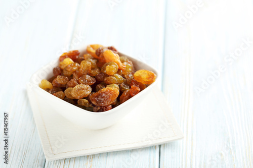 Dried raisins on a blue wooden table