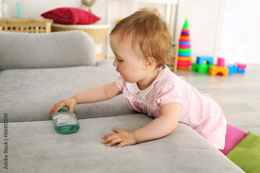 Baby with bottle on sofa in room Baby with bottle on sofa in room