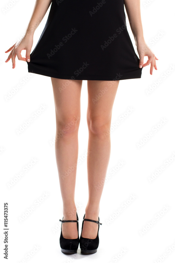 Woman holds dress with hands. Legs in black shoes. Suede footwear and cotton garment. Beautiful evening wear. Woman holds dress with hands. Legs in black shoes. Suede footwear and cotton garment. Beautiful evening wear.
