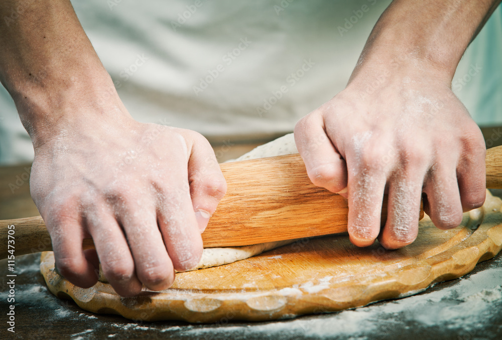 Making dough by mens hands on wooden table background Making dough by mens hands on wooden table background