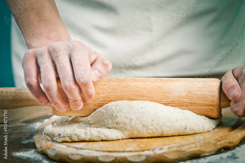Making dough by mens hands on wooden table background
