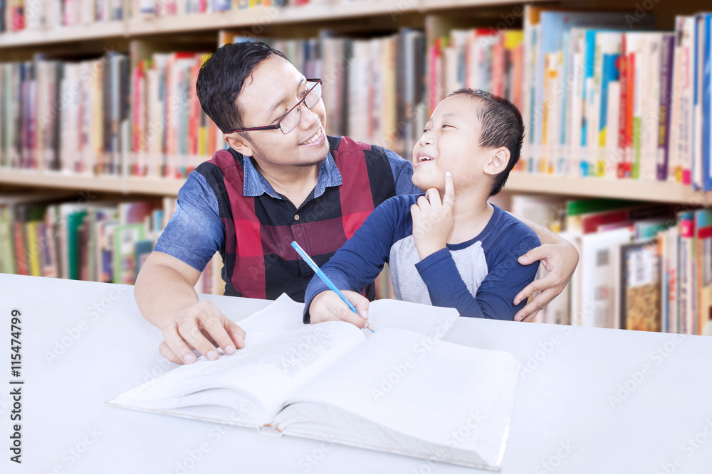 Man teaching a boy in the library Man teaching a boy in the library