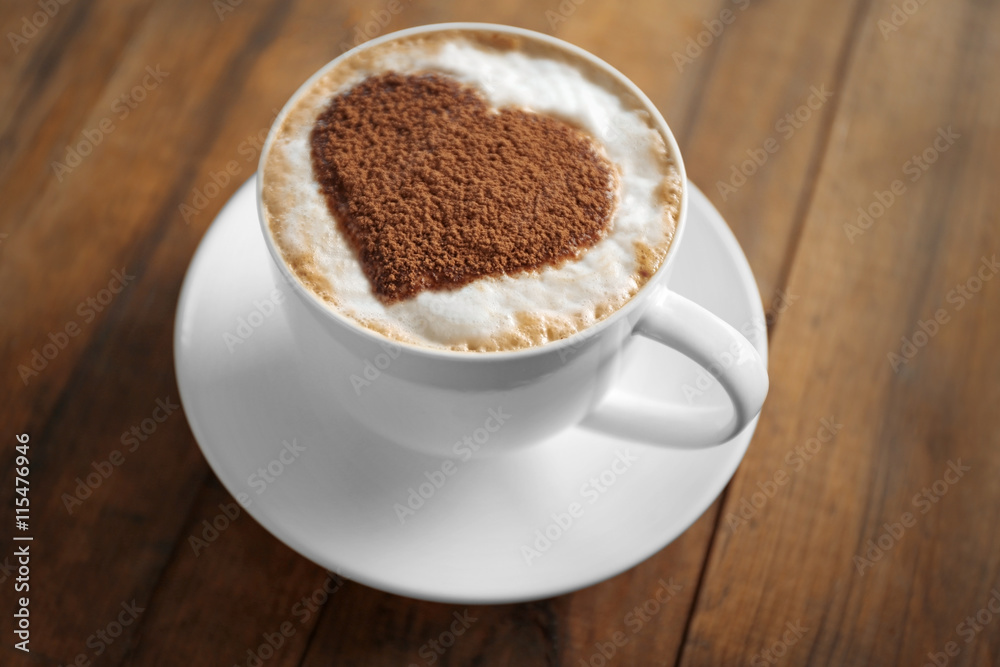 Cup of coffee with creative pattern on wooden table Cup of coffee with creative pattern on wooden table