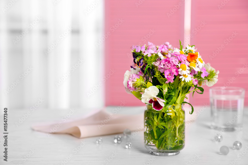 Meadow flowers bouquet in glass vase on table Meadow flowers bouquet in glass vase on table