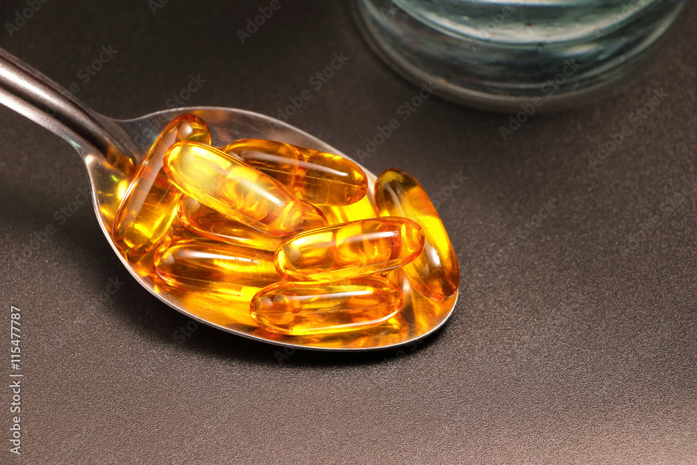 Fish oil in spoon with black background Fish oil in spoon with black background
