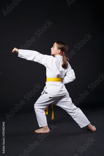 Child girl in karate suit with yellow belt show stance © Prostock-studio