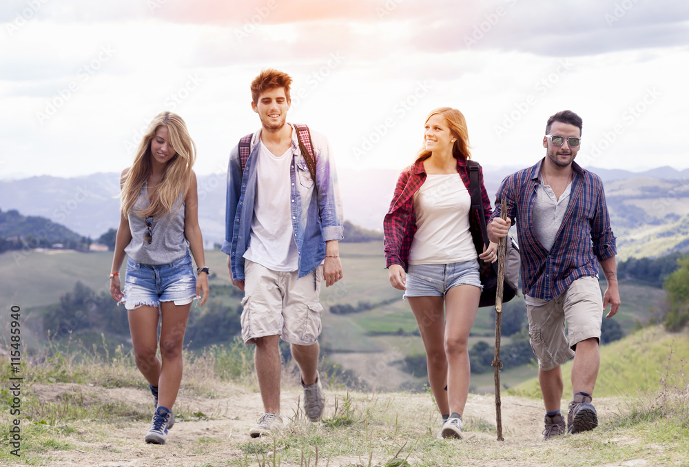 group of young hikers walking toward the horizon over the mounta group of young hikers walking toward the horizon over the mounta