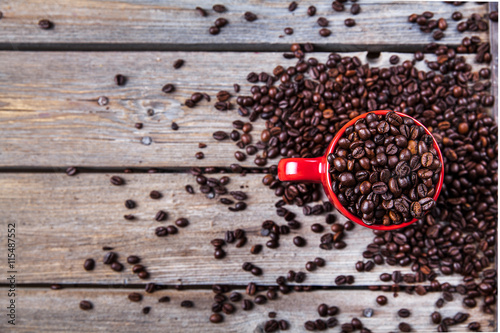 Coffee beans and red coffee cup on wooden background. Drink