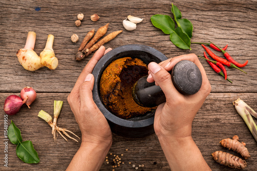 Fototapeta Naklejka Na Ścianę i Meble -  The Women hold pestle with mortar and spice red curry paste ingr