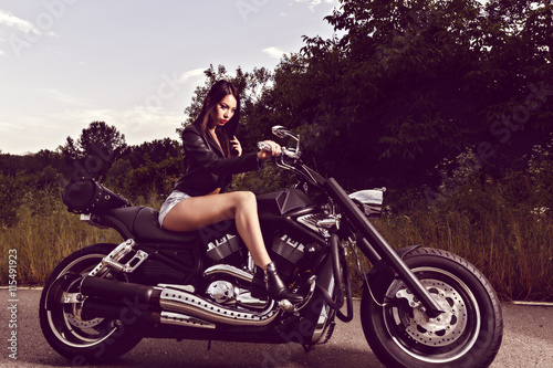 beautiful young woman posing with a motorcycle