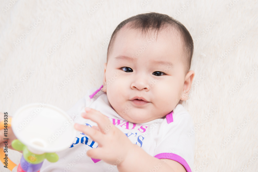 Adorable baby girl lying on white blanket