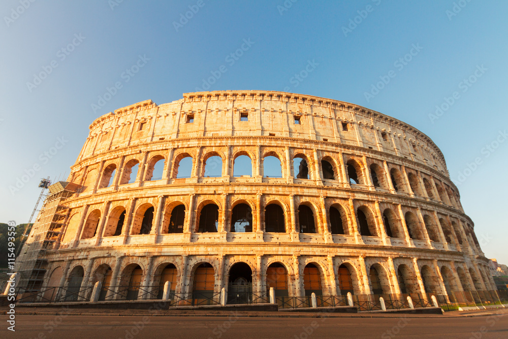 view of famous ruins of Colosseum at sunrise in Rome, Italy