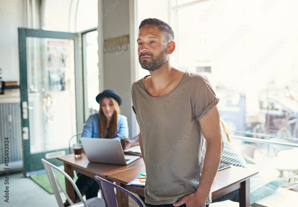 Serious man standing in cafe with open door Serious man standing in cafe with open door