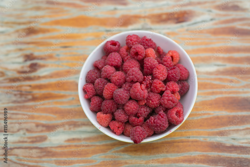 TOP VIEW: A dish with a raspberries on a table TOP VIEW: A dish with a raspberries on a table