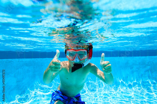 happy boy swimming underwater with thumbs up
