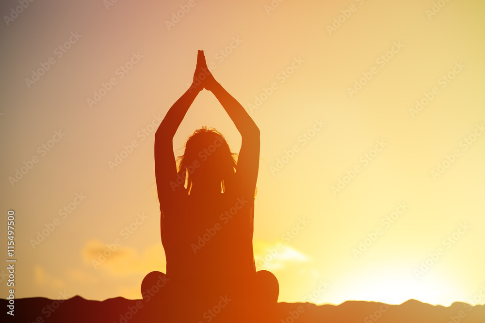 young woman doing yoga on sunset