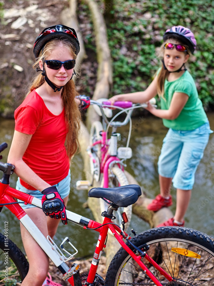Naklejka premium Bikes cycling girl. Girl rides bicycle. Girl cycling fording throught water on log. Cycling trip is good for health. Cyclist watch your step.