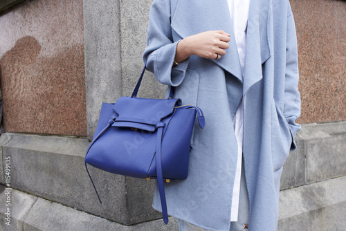Midsection of woman holding handbag outdoors