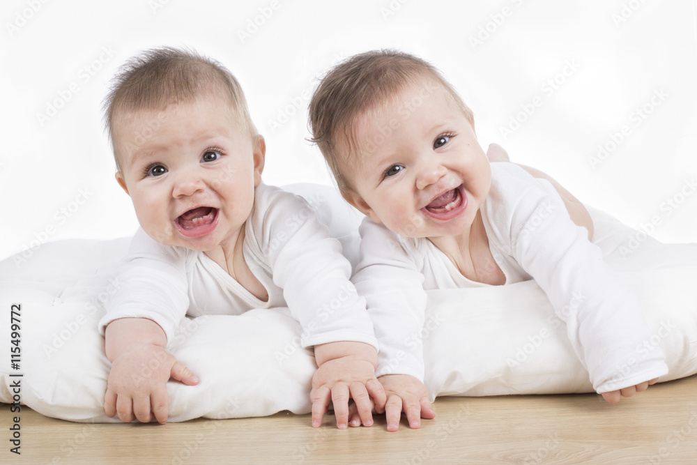 smiling happy twin baby girls on tummy smiling happy twin baby girls on tummy