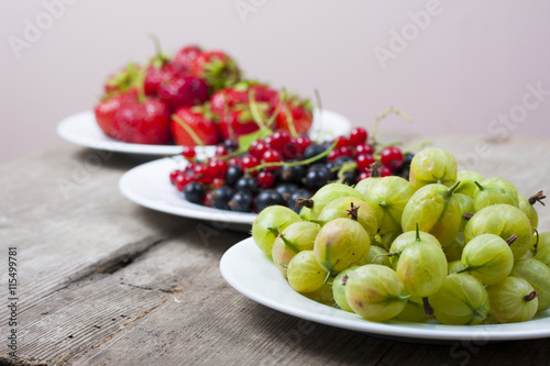 Summer berries on a wooden table.Goosbery, strawberry,black, red