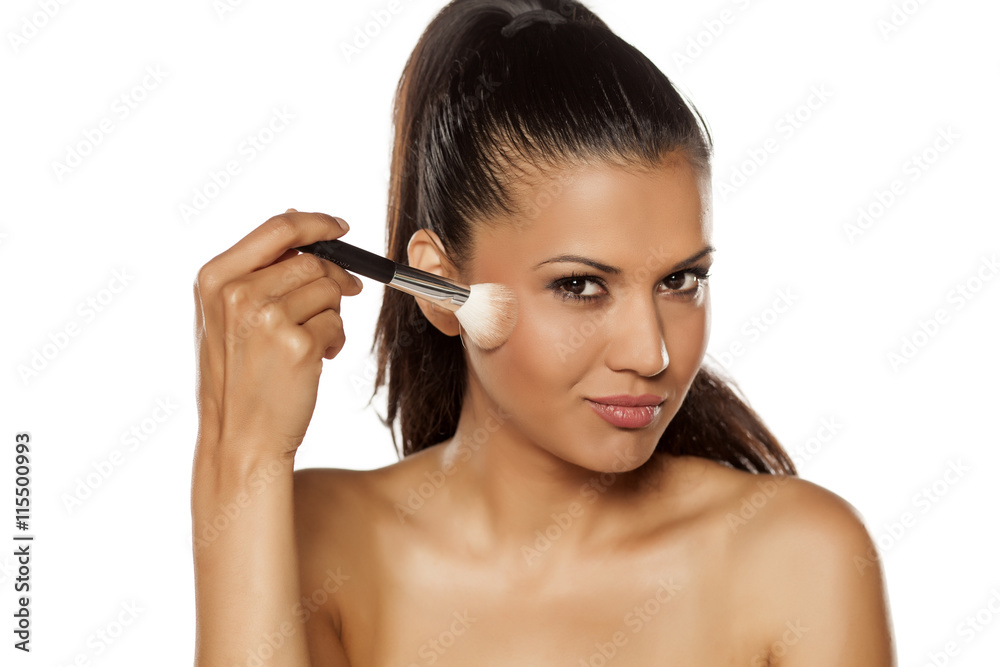 a young Indian woman posing with a brush for makeup a young Indian woman posing with a brush for makeup