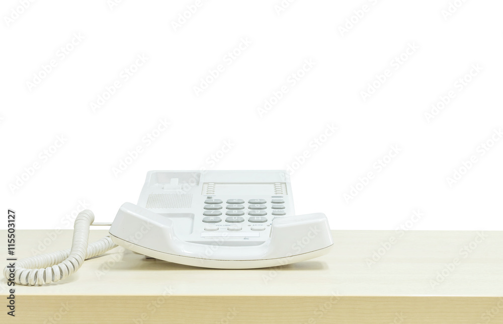 Closeup white phone , office phone on blurred wooden desk in the meeting room under window light isolated on white background Closeup white phone , office phone on blurred wooden desk in the meeting room under window light isolated on white background
