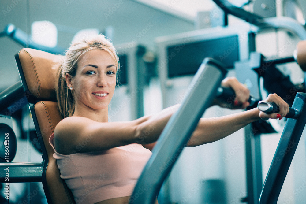 Gym girl exercising on a rowing machine Gym girl exercising on a rowing machine