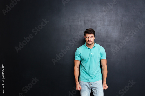 Angry irritated young man stnding and looking away