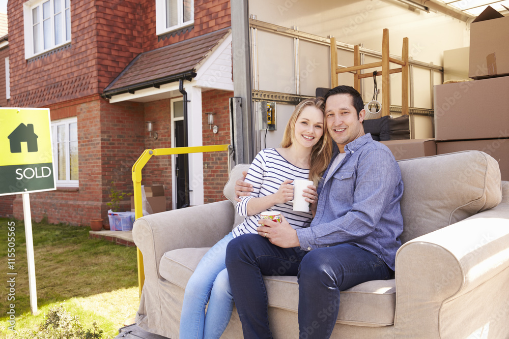 Couple With Sofa On Tail Lift Of Removal Truck Moving Home Couple With Sofa On Tail Lift Of Removal Truck Moving Home