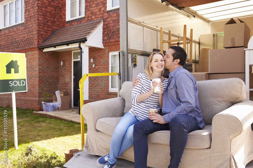 Obraz premium Couple With Sofa On Tail Lift Of Removal Truck Moving Home