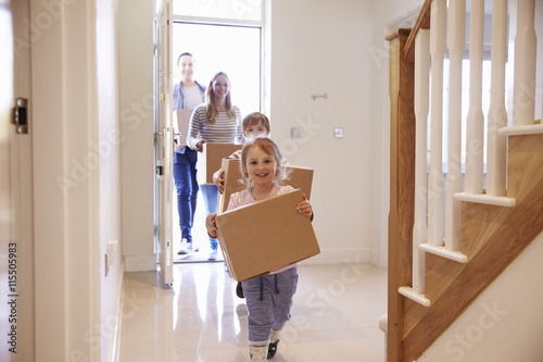 Family Carrying Boxes Into New Home On Moving Day photo