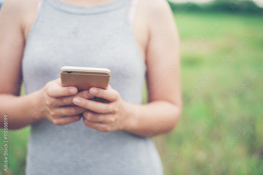 Young woman hands typing smartphone in the park. Young woman hands typing smartphone in the park.