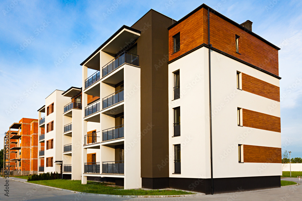 New block of apartment buildings stand in uninhabited suburb.