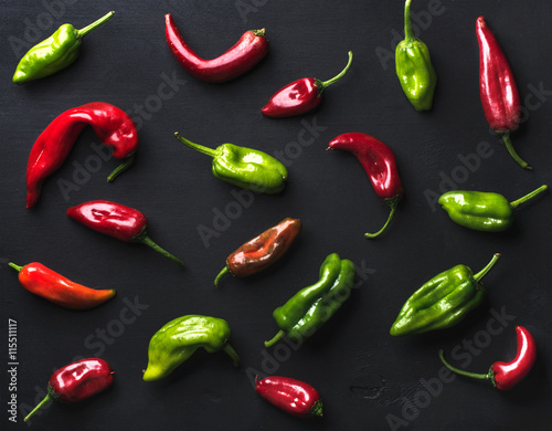 Pattern of small colorful hot chili peppers on black background
