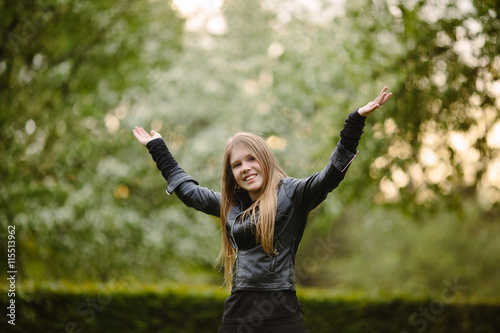 portrait of beautiful happy girl in black leather jacket on the green background