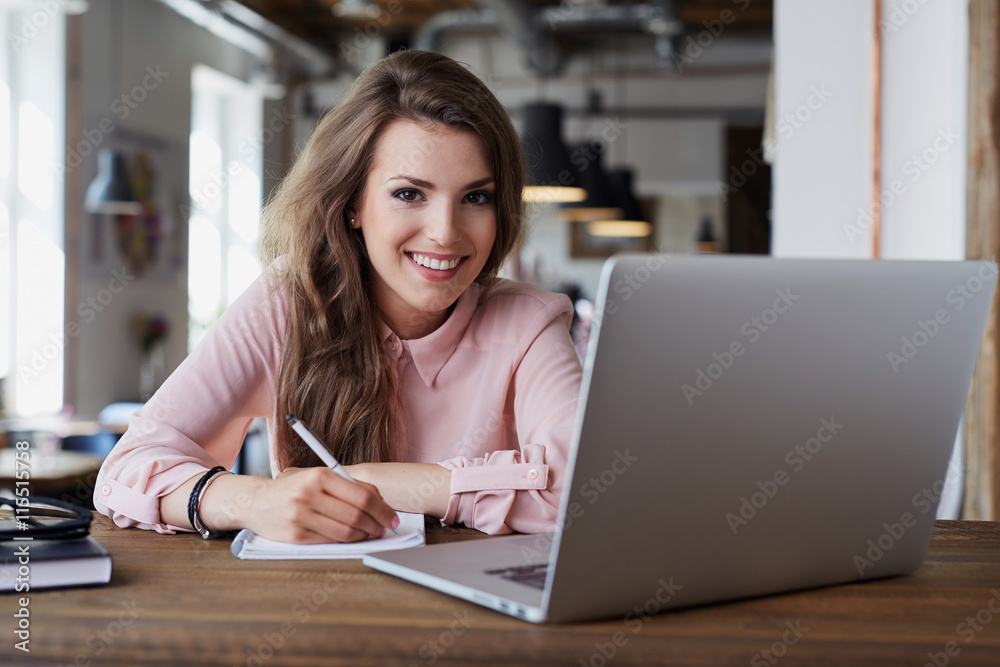 Portrait of happy young woman sitting at cafe with laptop and no Portrait of happy young woman sitting at cafe with laptop and no