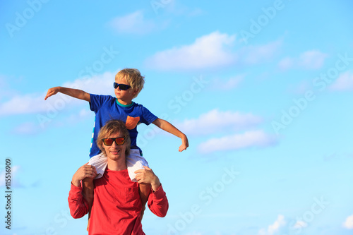 Father and little son playing on sky