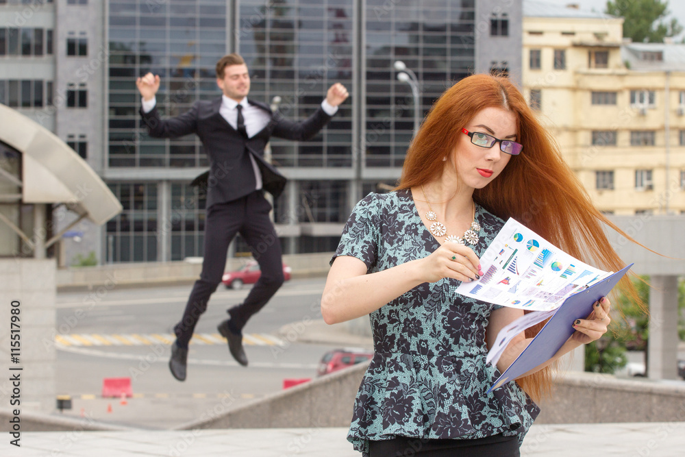Fototapeta premium Red-haired businesswoman and businessman on background