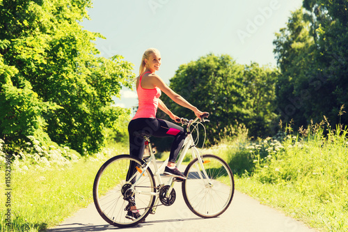 happy young woman riding bicycle outdoors