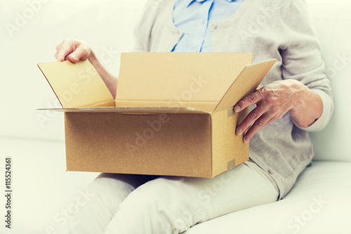 close up of senior woman with parcel box at home