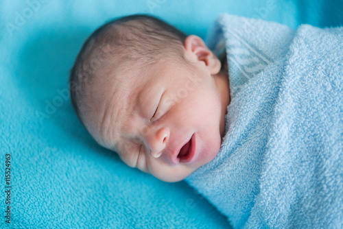Newborn baby Asia  while sleeping covered with blue cloth