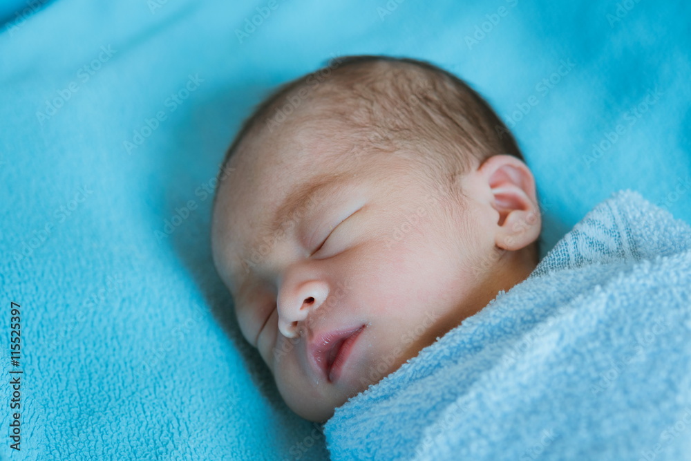 Newborn baby Asia while sleeping covered with blue cloth Newborn baby Asia while sleeping covered with blue cloth