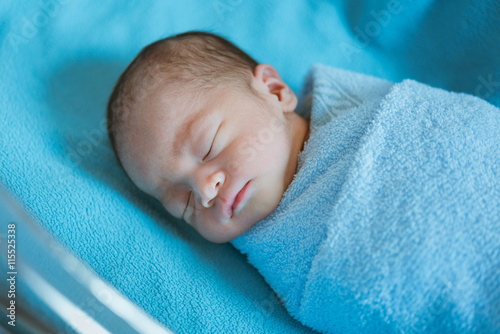 Newborn baby Asia  while sleeping covered with blue cloth