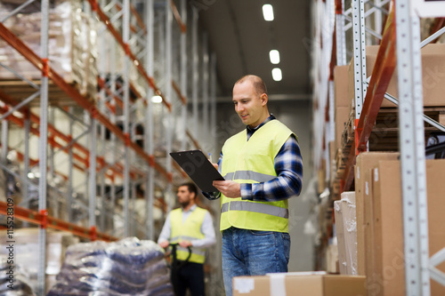 man with clipboard in safety vest at warehouse