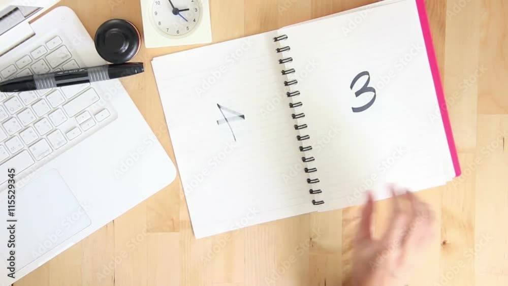 Top View Of Businesswoman Flip Numbers One-Ten On Notebook. Top View Of Businesswoman Flip Numbers One-Ten On Notebook.
