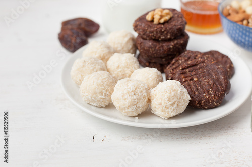 Raw vegan paleo style cookies selection, made with nuts, coconut oil, honey and dates, selective focus on closest macaroon