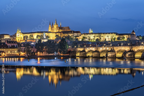 Night view over river Vltava and Charles bridge to Prague castle with copy space in clear sky © Valerie2000